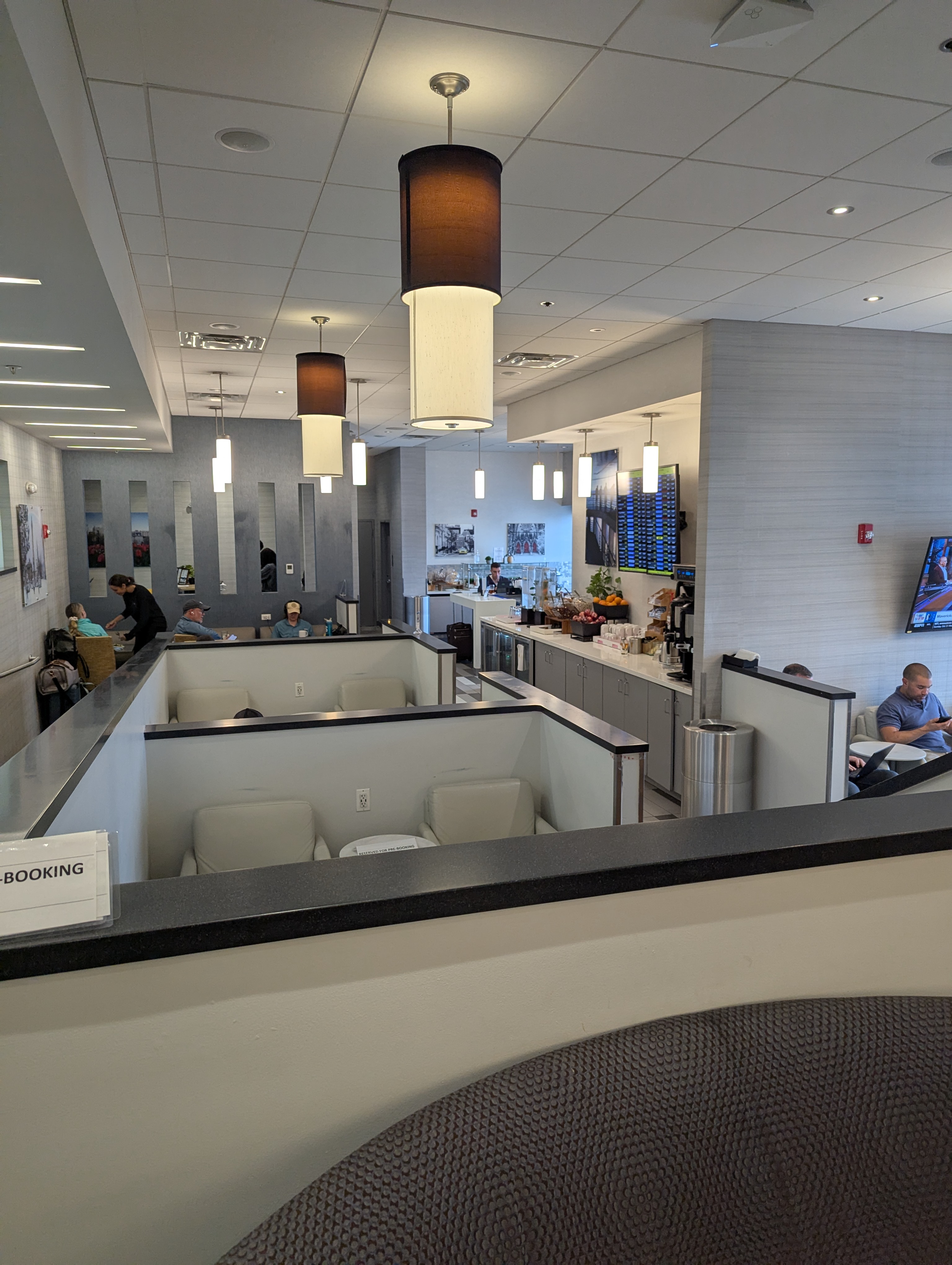 Interior seating and refreshment area inside The Club BWI lounge near Gate D10